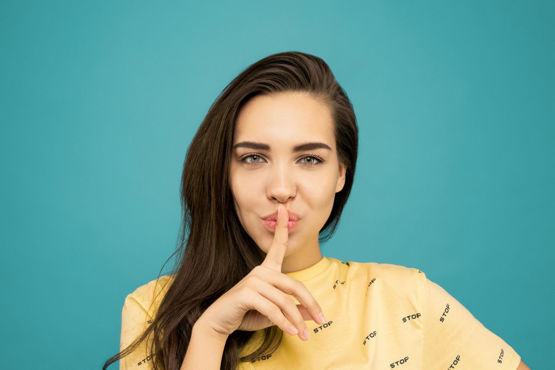 Frau mit Zeigefinger vor dem Mund