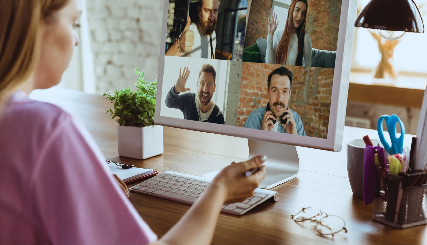 Frau sitzt vor PC und ist in einem virtuellen Meeting